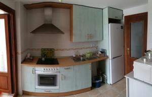 a kitchen with white cabinets and a white refrigerator at Apartamento Canela in Ayamonte