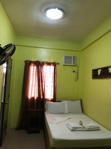 a small bedroom with a bed with a window at Luis Bay Travellers Lodge in Coron