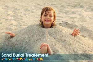 a young girl laying in a sand ball on the beach at Kato Dool Wellness Resort in Aswan