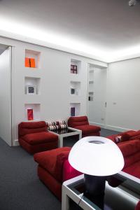 a living room with red couches and a table at Hotel Italia in Cagliari