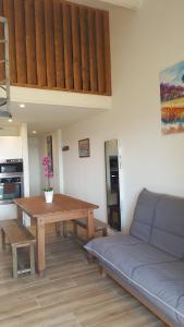 a living room with a table and a couch at Appartement CAPBRETON face à l'océan sans vis à vis, avec piscine in Capbreton