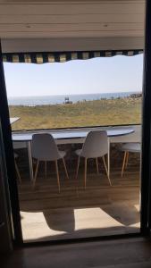 カップブルトンにあるAppartement CAPBRETON face à l'océan sans vis à vis, avec piscineのビーチの景色を望むテーブル(椅子2脚付)