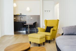 ein Wohnzimmer mit einem gelben Stuhl und einem Tisch in der Unterkunft Stina Apartment in Split