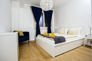ein Schlafzimmer mit einem weißen Bett mit blauen Vorhängen und einem Kronleuchter in der Unterkunft Stina Apartment in Split