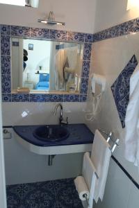 bagno con lavandino e specchio di La Ginestra a Panarea