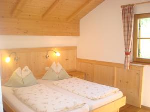 1 dormitorio con 2 camas y ventana en Singerhof en Castelrotto