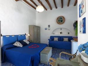 a living room with a blue bed and a couch at La Ginestra in Panarea