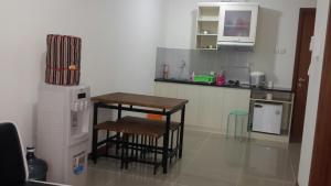 uma cozinha com uma mesa, 2 bancos e um frigorífico em Robert's Condominium em Jacarta