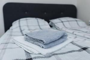 einen Stapel Handtücher auf dem Bett in der Unterkunft MainStreet apartman in Subotica