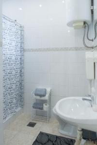 ein Bad mit einem Waschbecken, einem WC und einer Dusche in der Unterkunft MainStreet apartman in Subotica