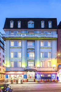 un gran edificio con un cartel en la parte delantera en Hôtel Notre Dame de France en Lourdes