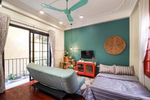 um quarto com uma cama e uma cadeira e uma televisão em Little Anh House em Hanói