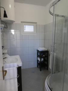 a white bathroom with a sink and a shower at AP3-obala in Punat