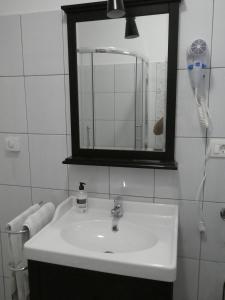 a bathroom with a sink and a mirror and a phone at AP3-obala in Punat