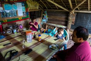 a group of people sitting at a table with food at Castle Tree House And Bungalow in White Sands