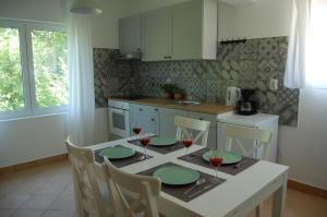 a kitchen with a table with green plates and wine glasses at Nia Apartment in Jadranovo
