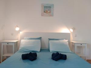 a bed with blue sheets and two pillows on it at Nia Apartment in Jadranovo