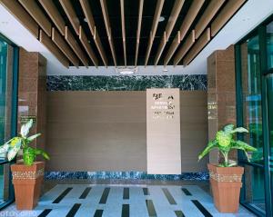 a lobby of a building with two plants at Beta Service Apartment in Labuan
