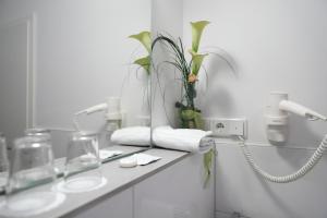 a bathroom with a counter with glasses and a phone at Hotel 12 Bäume in Werne an der Lippe