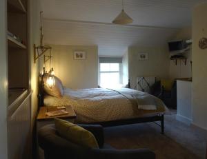 a bedroom with a bed and a table and a couch at Ty Capel in Machynlleth