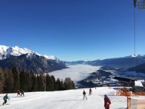 a group of people skiing down a snow covered slope at Roslerhof in Inzing