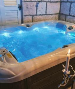 eine blaue Badewanne mit einer Kerze im Bad in der Unterkunft Apartments Cezar in Rogoznica