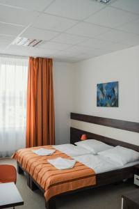 a bedroom with two beds and an orange curtain at Sport-Relax Centrum Bors Club in Břeclav