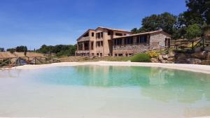 a large pool of water in front of a house at B&B Casale di Poggioferro in Scansano