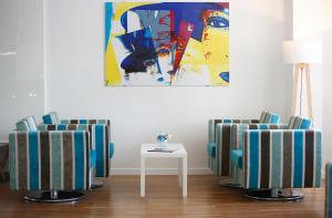 a room with two chairs and a table and a painting at Hôtel Méditerranée in Calvi