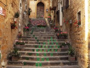 un conjunto de escaleras en un callejón con flores en Bed and Breakfast Baobab en Piazza Armerina