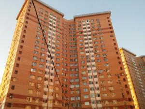 ポドリスクにあるInnDays Ленинградская 11の高いオレンジ色のアパートメントビル(窓付)