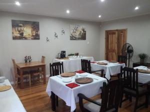 a dining room with white tables and chairs at The Tides Inn Bed and Breakfast in Durban