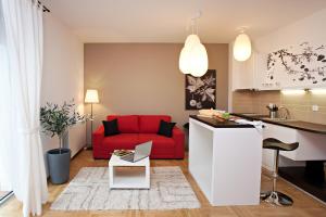 a kitchen and a living room with a red couch at Boutique Apartments 360º in Belgrade +12 photos