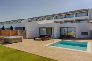 a house with a swimming pool in front of it at Abaton Island Resort & Spa in Hersonissos