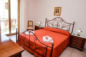 a bedroom with a bed with a red blanket and a table at Casa Noto in Marettimo