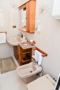 a white bathroom with a sink and a toilet at Casa Noto in Marettimo