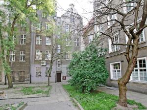 een appartementencomplex met een boom ervoor bij Apartament Kameralny Długa 50 in Gdańsk