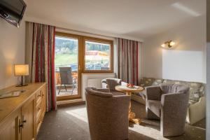 - un salon avec un canapé, des chaises et une table dans l'établissement Hotel Garni Klocker, à Kaltenbach