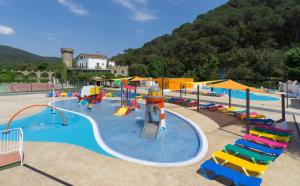 a swimming pool filled with lots of colorful chairs and umbrellas at Medplaya Aparthotel Sant Eloi in Tossa de Mar