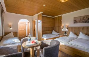a bedroom with two beds and a table and chairs at Hotel Garni Klocker in Kaltenbach