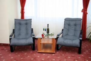 zwei Stühle und ein Tisch mit einer Flasche Wein in der Unterkunft Hotel Calarasi in Călăraşi