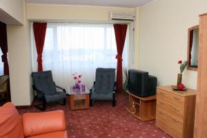 - un salon avec deux chaises et une télévision dans l'établissement Hotel Calarasi, à Călăraşi