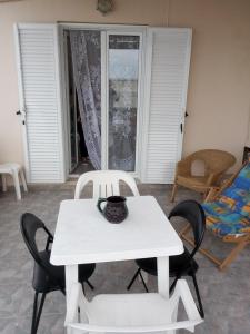 a white table and chairs in a living room at Soulas apart -Ρέα- in Ano Syros