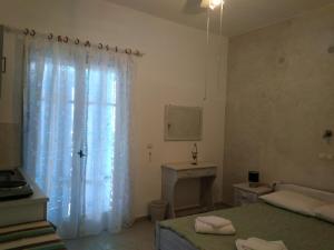 a bathroom with two beds and a window with a sink at Anastasia in Aliko Beach