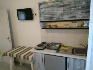 a kitchen with a counter with a sink and a table at Anastasia in Aliko Beach