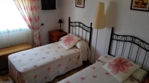 エステポナにあるVilla Charoのベッドルーム1室(花の飾られたベッド2台付)