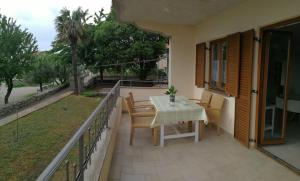 patio con mesa y sillas en el balcón en Simonetti Apartments Malinska, en Malinska