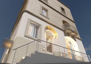 a large white building with a staircase in front of it at Ta Gianni Guest House in Sliema