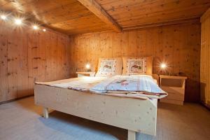 a bedroom with a bed in a wooden wall at Berghütte Schöpf in Umhausen