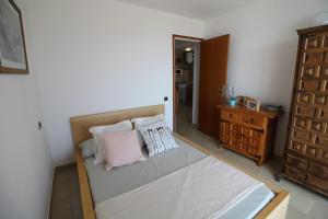 エンプリアブラバにあるBasic Comfort Apartment Karina 16º 0102のベッドルーム1室(枕2つ、鏡付)